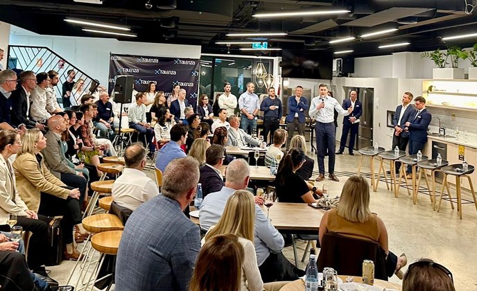 Photo of the panel and crowd at the AI in Cancer Research Panel Discussion at The Transformation Group
